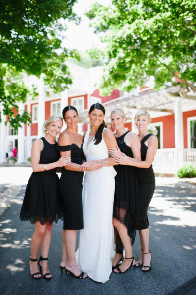 A bride and her bridesmaids in the drive in front of the Inn at Black Star Farms.