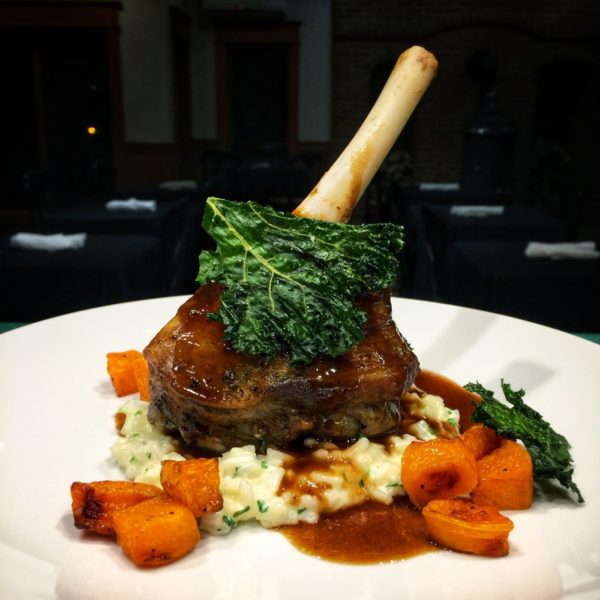 Roasted lamb chop entree with mashed potatoes, and carrots.