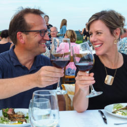 Couple toasting red wine at the Arcturos Dining Series in the vineyard.