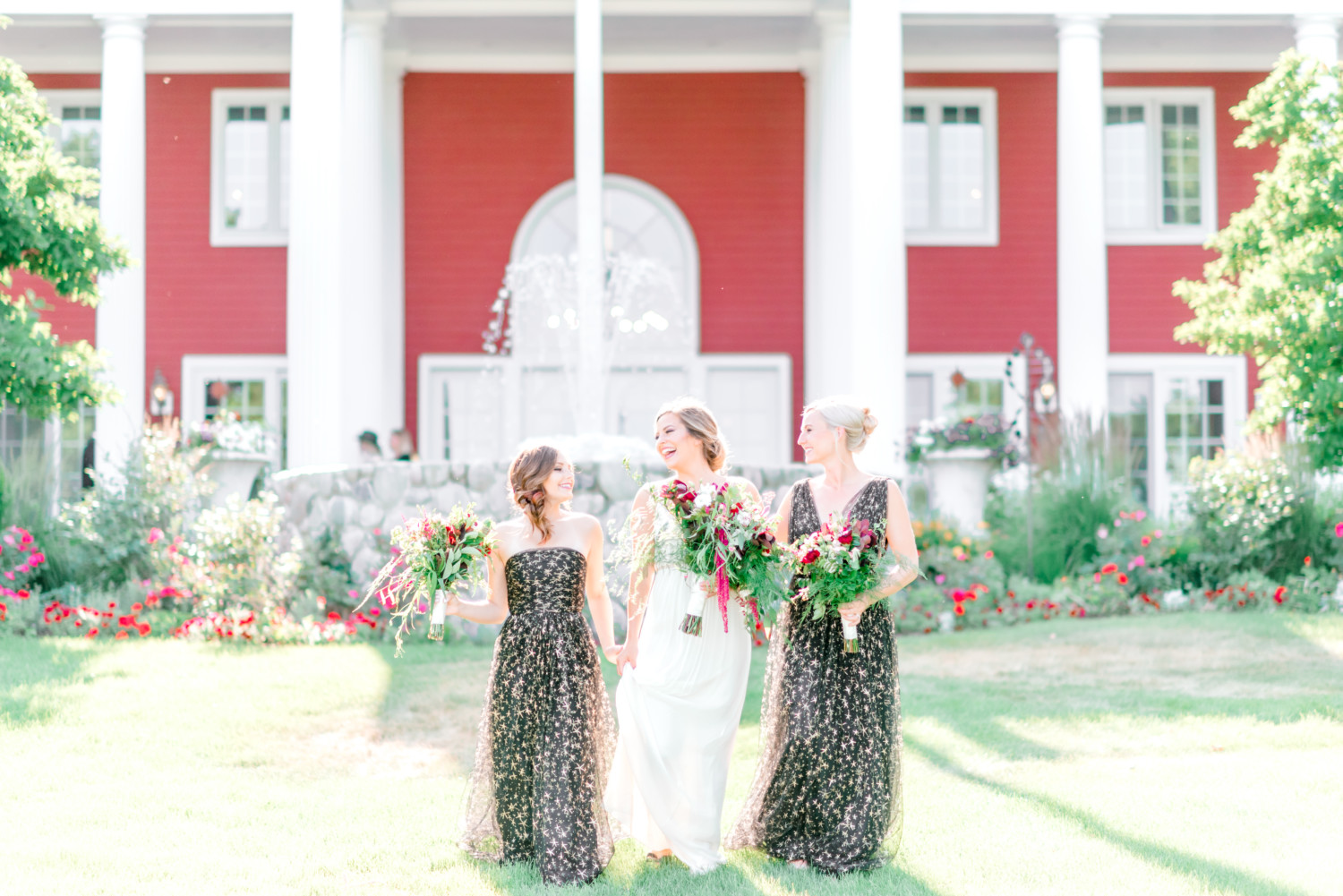A bride and her two bridesmaids in front of the fountain an the Inn at Black Star Farms, one of the best Traverse City wedding venues