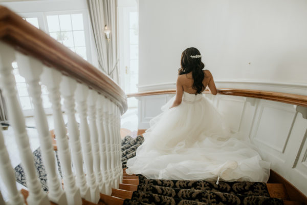 Bride descending the spiral staircase in the front foyer of the Inn at Black Star Farms.