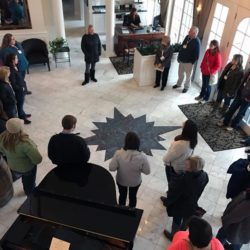 Tour group standing around the star on the floor of the foyer at the Inn at Black Star Farms, part of our Estate & Wine Tasting Tours.