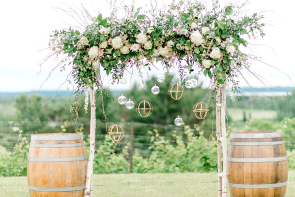 Wedding alter with flowers and wine barrels in the vineyard.
