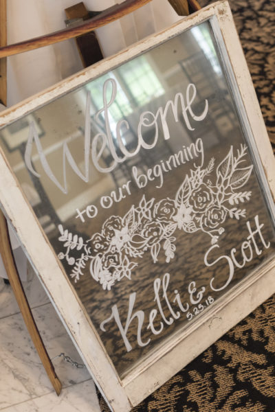 Sign painted on an old window that says, "welcome to our beginning."