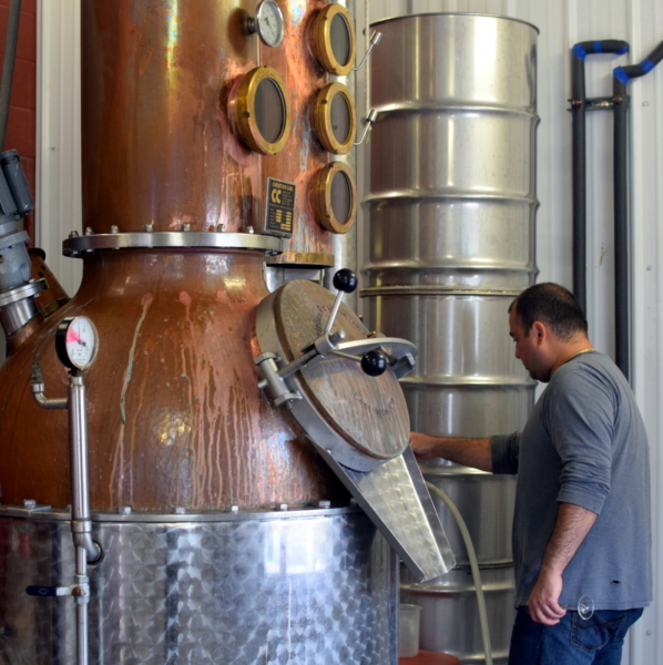 Employee monitoring the fruit brandy still at Black Star Farms Old Mission.