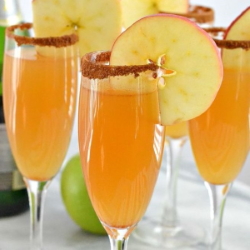 Example of cinnamon rimmed Apple Cider Mimosas with garnished with fresh apple wheel.