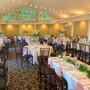 Aquarius Room set for a wedding reception with strung lights and tall flower arrangements.