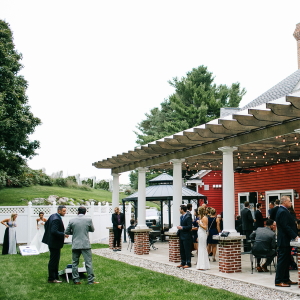 Wedding guests enjoying the covered patio and lawn off the back of the Inn at Black Star Farms.