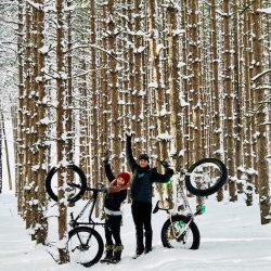 A couple with fat tire bikes in the snow.