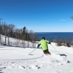 Man downhill skiing at the Homestead Resort overlooking Lake Michigan.