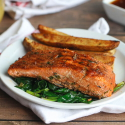 Example of salmon with Jamaican jerk seasoning over spinach with roasted potato wedges.