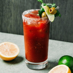 Bloody Mary cocktail with lime and olive garnish.