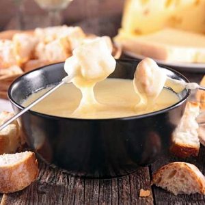 Dipping bread into cheese fondue, one of the pairings suggested in this blog post.