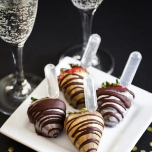 Chocolate covered strawberries with glasses of sparkling wine.