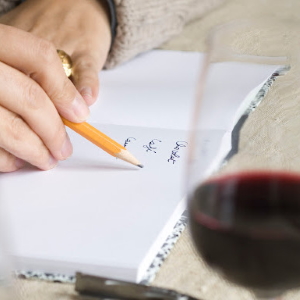 Person taking wine tasting notes.
