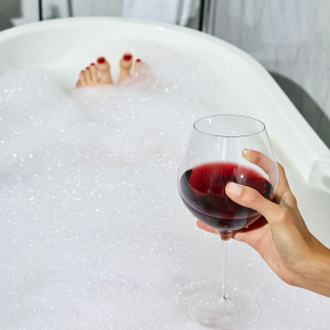 Soaking in a bubble bath with a glass of red wine.
