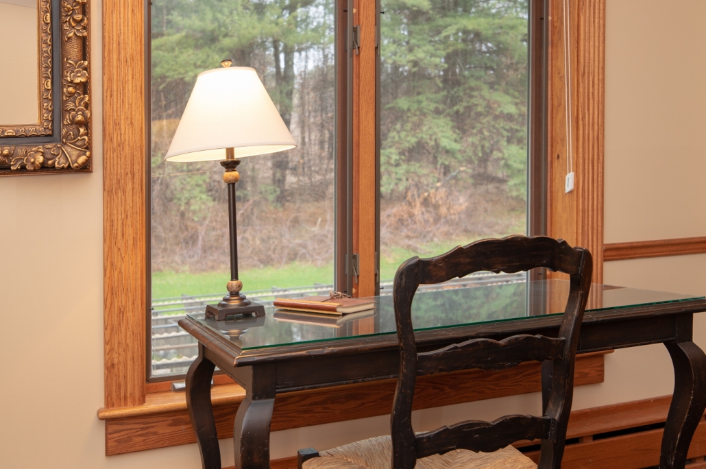 Writing desk with windows overlooking the forest.