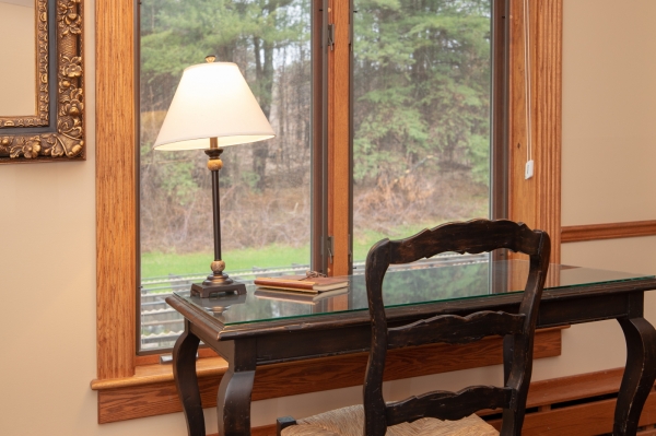 Writing desk with windows overlooking the forest.