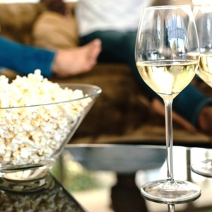 Bowl of popcorn with white wine.