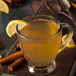 A hot toddy in a mug with lemon wedge.