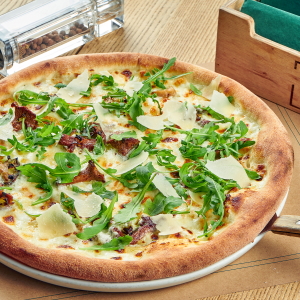 White pizza topped with arugula.