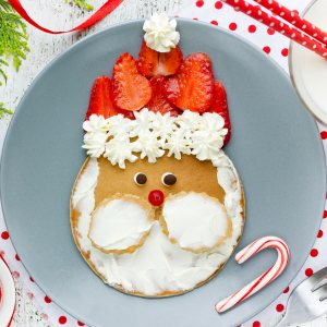 Pancake decorated as Santa with whipped cream and strawberries.