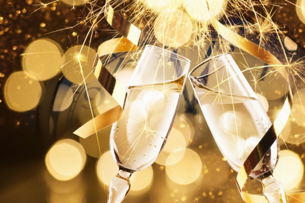 Flutes of sparkling wine giving cheers with a festive background.