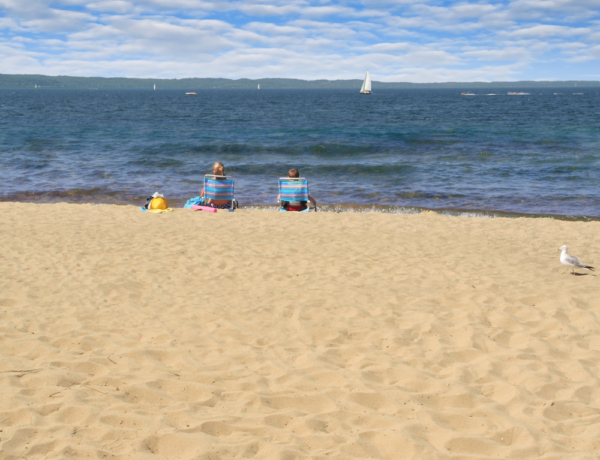 Two people sitting on a Traverse City Beach enjoying a summer afternoon