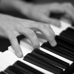 Close up of hands playing a piano.