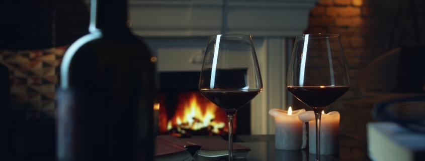 Glasses of red wine by the fireplace - a cozy winter wine tasting on the Leelanau Peninsula Wine Trail