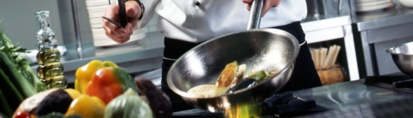 Chef sautéing vegetables in pan.
