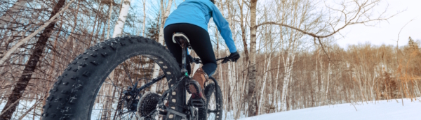 Woman fat tire biking in the snow - one of our favorite things to do in Traverse City in the Winter