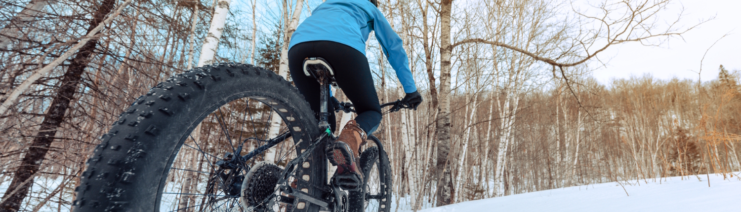 Woman fat tire biking in the snow - one of our favorite things to do in Traverse City in Winter