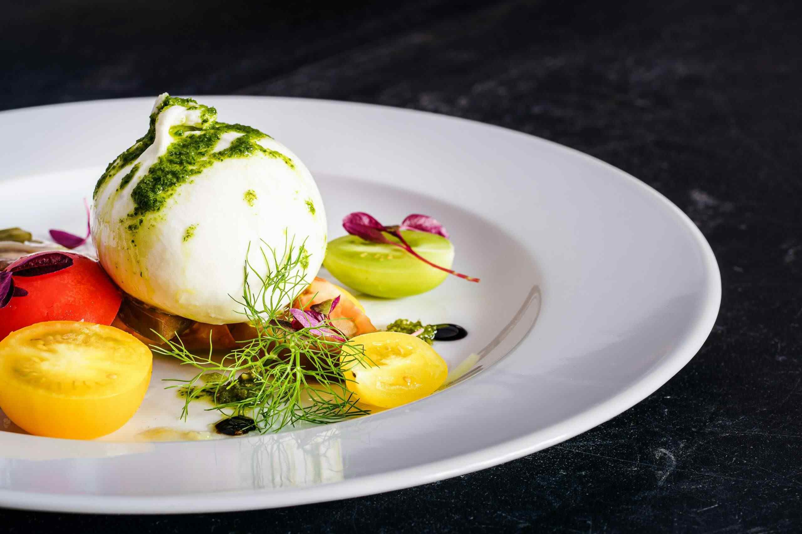 A white plate displaying a sunny-side-up egg accompanied by a vibrant mix of assorted vegetables.
