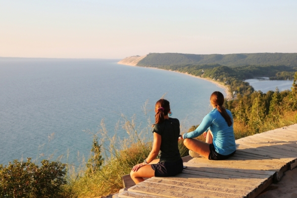 Two women sitting on the Boardwalk taking in the Views at the Sleeping Bear Dunes Overlook