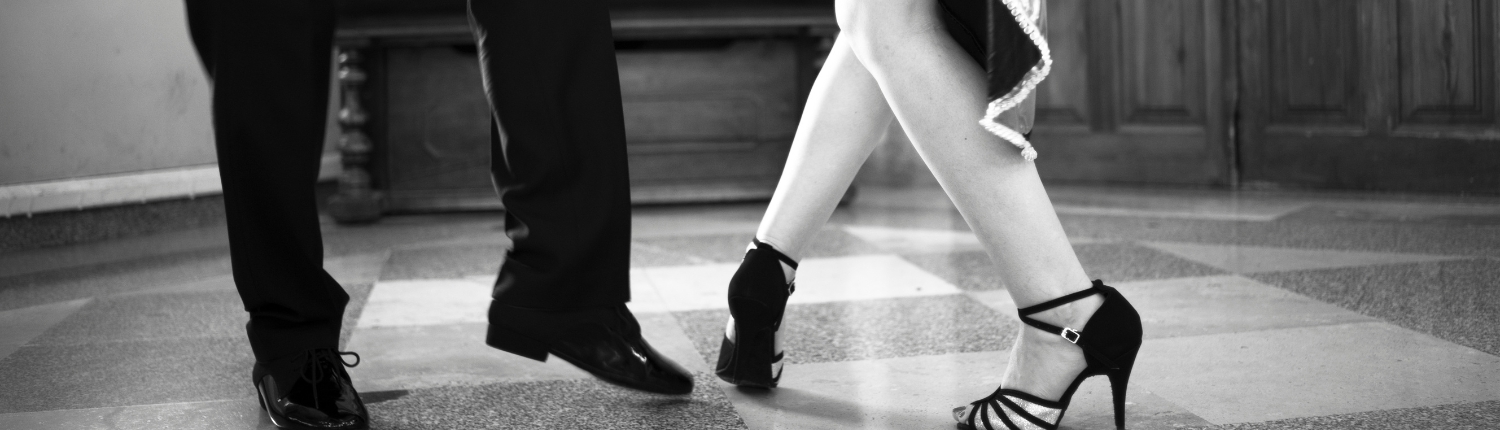 A close up of a couples feet dancing Latin-style.