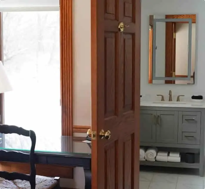A bathroom with a desk and a window, featuring a modern design and natural light.