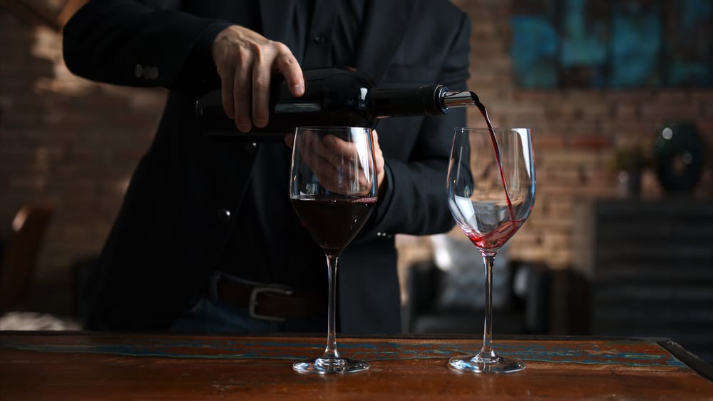 Elegant,Man,Pouring,Red,Wine,From,Wine,Bottle,To,Wine Romantic Getaway at our Bed and Breakfast in Traverse City 2