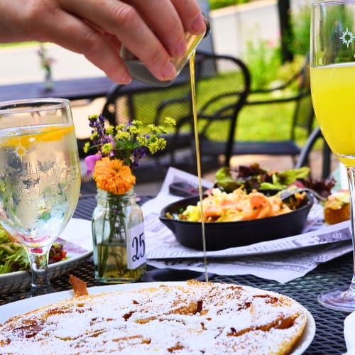 Brunch items and a mimosa on a patio table.