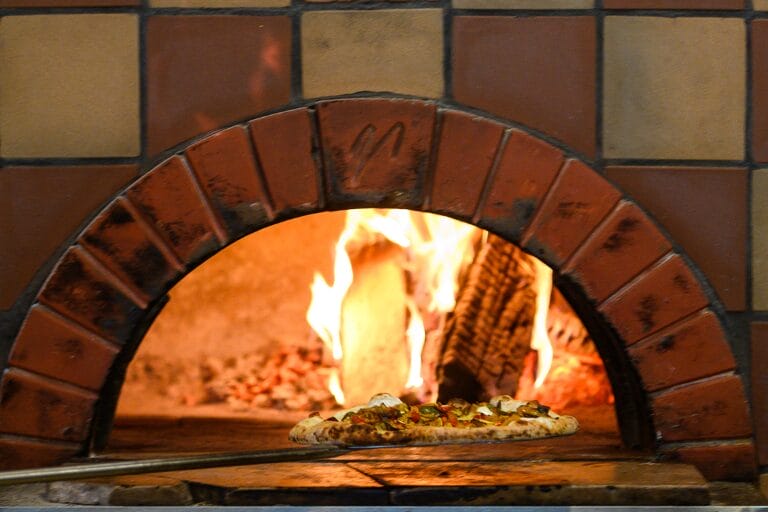 Pizza being pulled from the wood-fired oven.