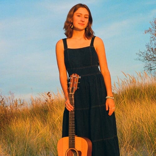 Live Music 1 Zinnia with an acoustic guitar in a field of dune grass.