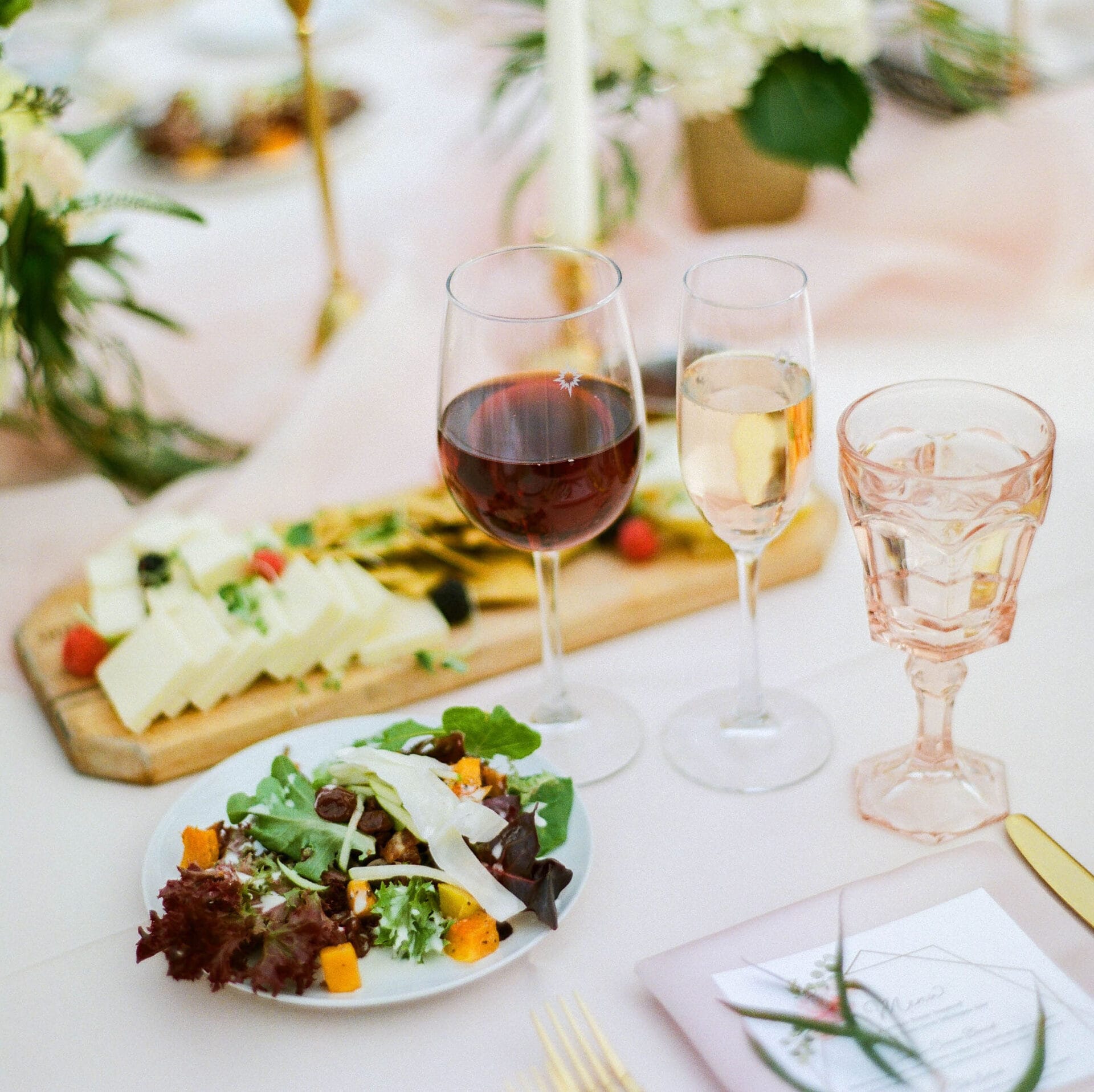 Weddings 65 A group of people sitting at a long table with wine glasses, enjoying a social gathering.