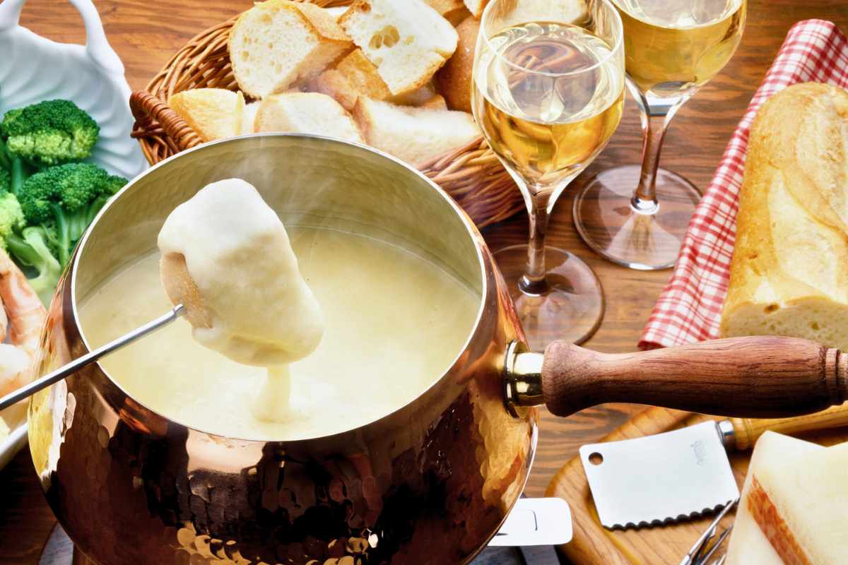 Dining 3 Cheese fondue with fresh bread and two glasses of white wine.