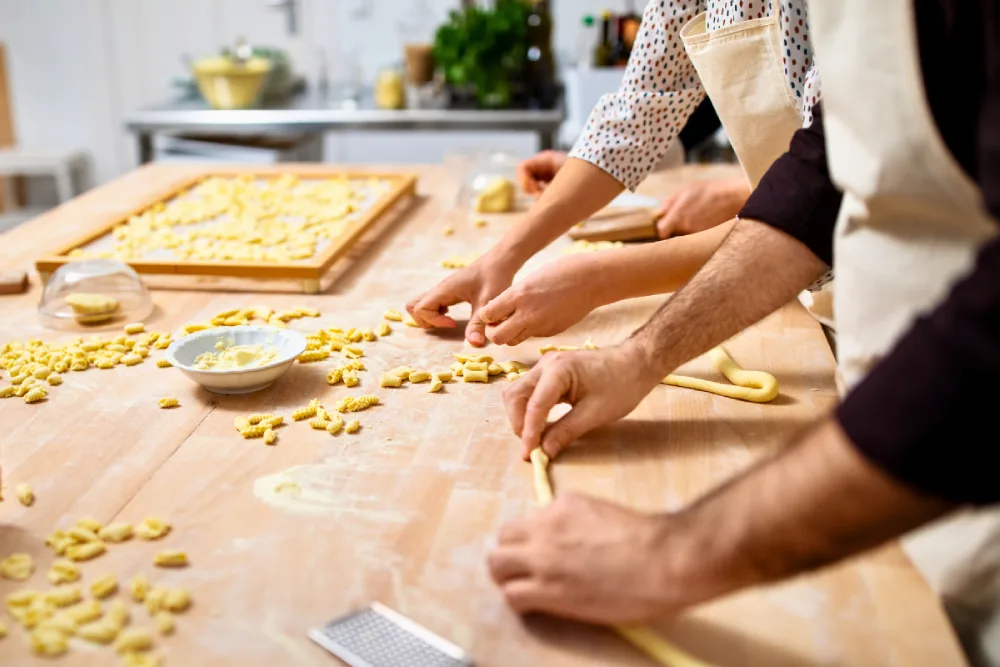 People making fresh pasta in a cooking class.