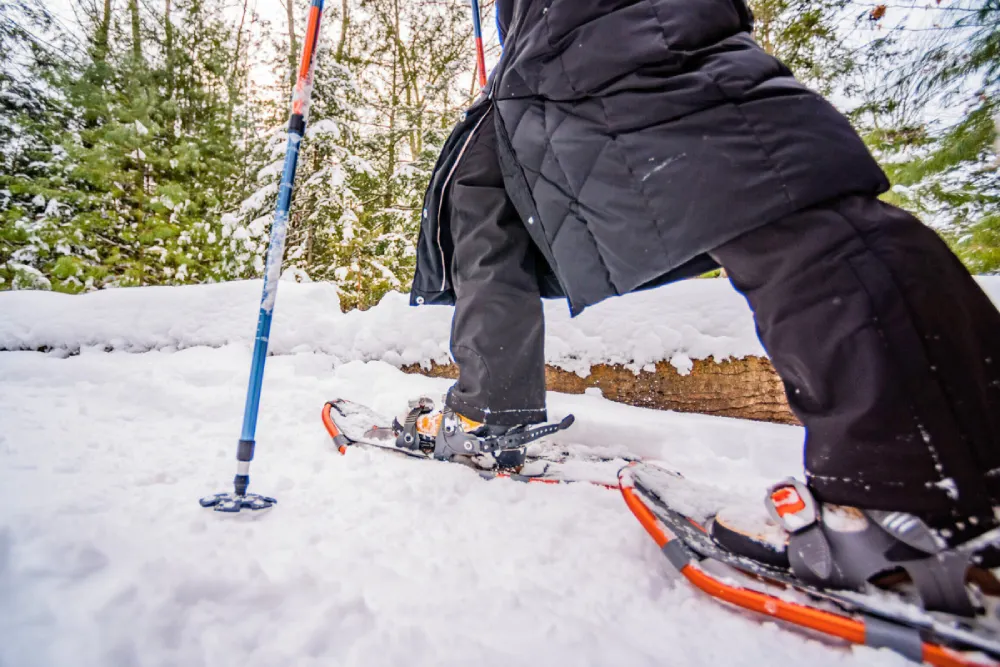 Person walking through snow close up with snowshoes on
