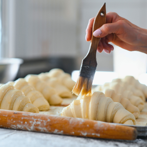 Divine Dough Winter School Person brushing prepared croissant dough